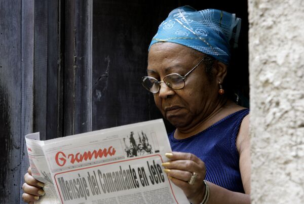 Una mujer leyendo el periódico Granma Una mujer leyendo el periódico Granma - Sputnik Mundo