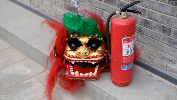 Una máscara de león y un extintor de incendios en Pekín, China - Sputnik Mundo