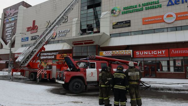 Los bomberos cerca del centro comercial quemado en Kémerovo - Sputnik Mundo