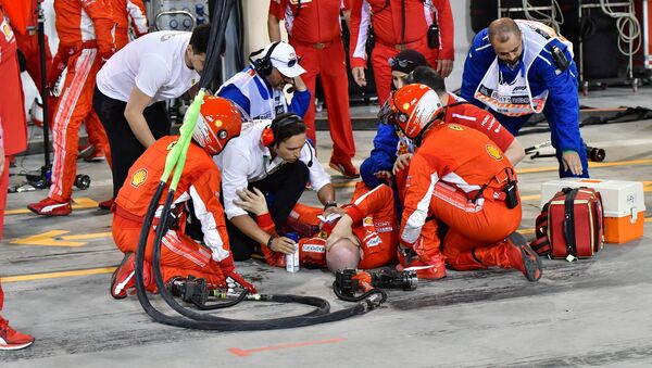 Un mecánico de Ferrari es atendido por sus compañeros después de un accidente durante durante el Gran Premio de Bahréin de F1 - Sputnik Mundo