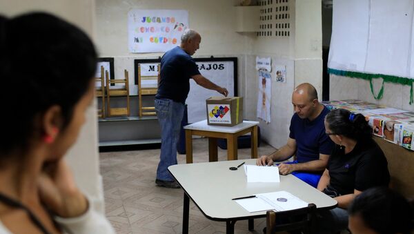 A Venezuelan casts his vote at a polling station during the presidential election in Caracas, Venezuela - Sputnik Mundo