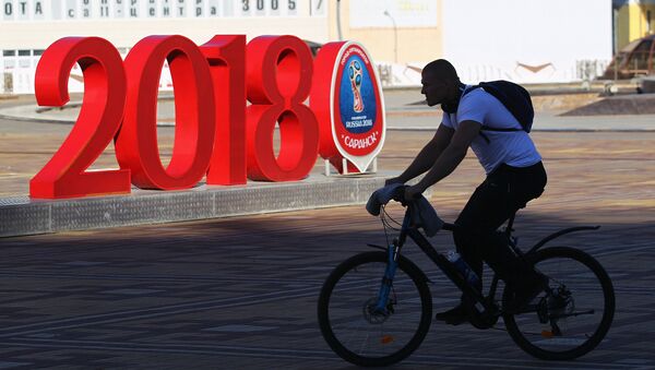 Hombre en bicicleta con el logo del Mundial de fútbol Rusia 2018 - Sputnik Mundo