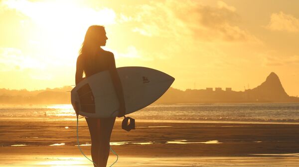 Una chica con una tabla de surf (imagen referencial) - Sputnik Mundo