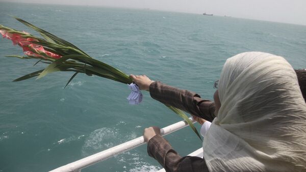 Una mujer iraní echa flores en el Golfo Pérsico durante una ceremonia que recuerda a los 290 pasajeros del vuelo 655 de Iran Air - Sputnik Mundo