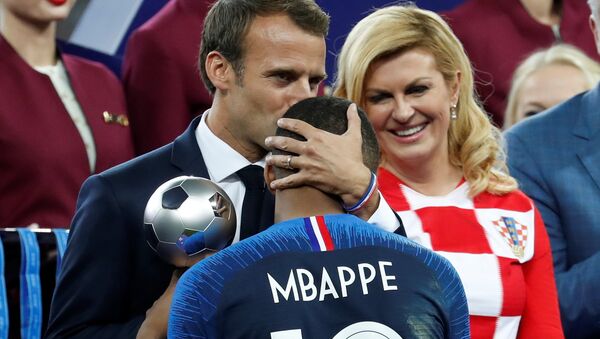 Emmanuel Macron, presidente de Francia, abraza a Kylian Mbappe, delantero de la selección francesa de fútbol, durante la ceremonia de premiación del Mundial de Rusia 2018 - Sputnik Mundo