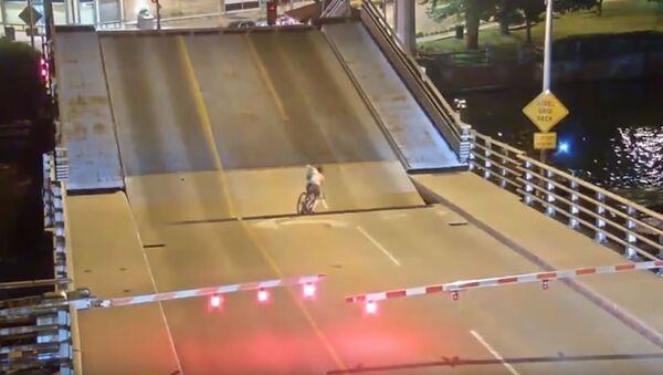 Ciclista cae bajo un puente levadizo - Sputnik Mundo