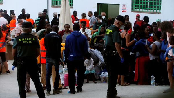Los migrantes durante una distribución de alimentos organizada por la Guardia Civil española - Sputnik Mundo