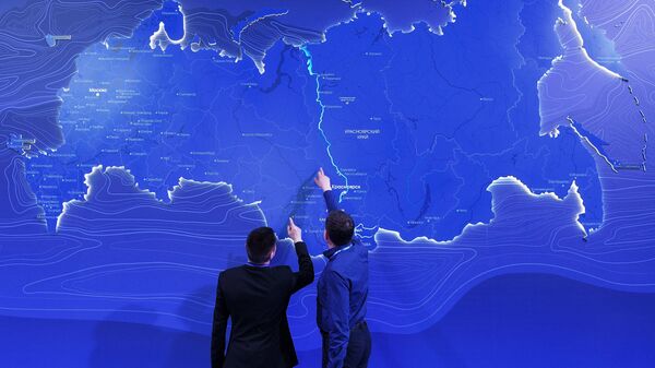 Hombres observando el mapa de Rusia en el Foro Económico de Krasnoyarsk (archivo) - Sputnik Mundo