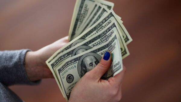 Una mujer cuenta los billetes de un dólar - Sputnik Mundo