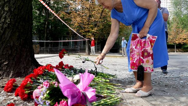 Mujer dejando una flor en santuario - Sputnik Mundo