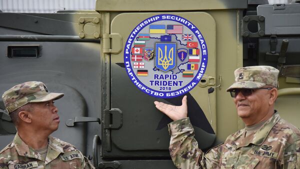 Militares junto con logo de los ejercicios militares Rapid Trident 2018 - Sputnik Mundo