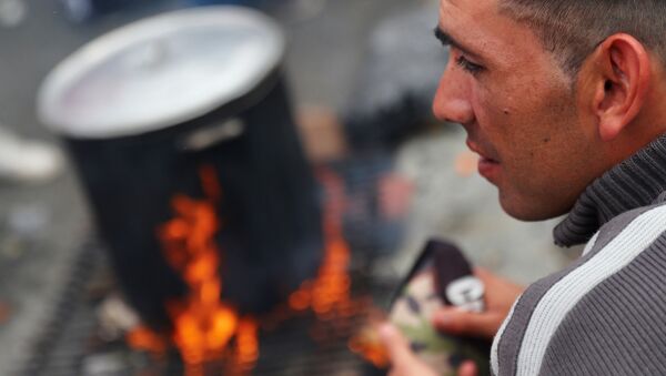 Un hombre espera por un plato de comida en una olla popular en Buenos Aires. - Sputnik Mundo