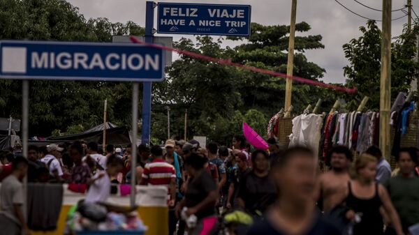 Miles de personas migrantes en el puente internacional entre Guatemala y México intentan cruzar para pedir el asilo mexicano - Sputnik Mundo