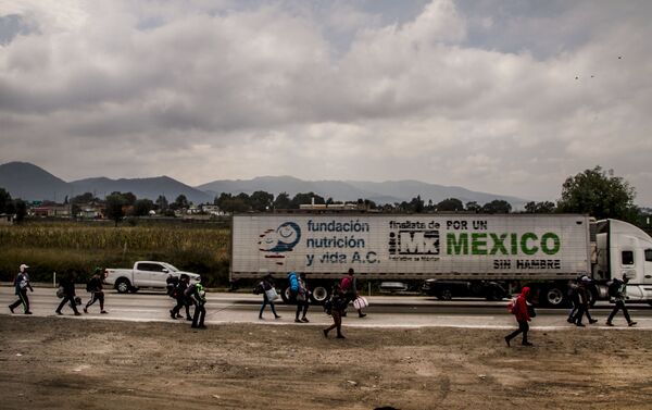 Hidalgo. Camión con la leyenda “por un México sin hambre” pasa frente a la caravana de centroamericanos que camina rumbo a Querétaro para descansar y seguir su camino a EEUU - Sputnik Mundo