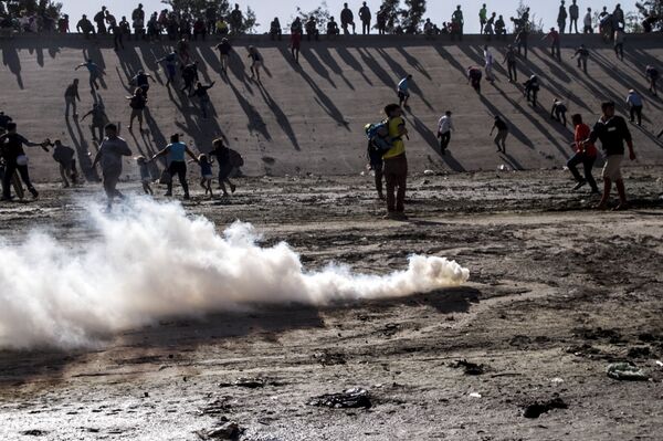 Manifestantes huyen del ataque con gases lacrimógenos de los elementos de la USBP (border patrol) al territorio mexicano Manifestantes huyen del ataque con gases lacrimógenos de los elementos de la USBP (border patrol) al territorio mexicano - Sputnik Mundo