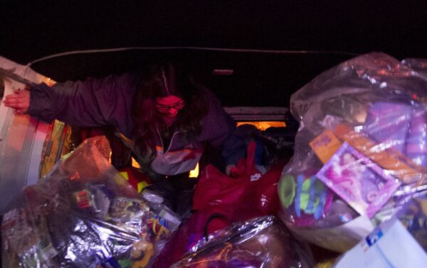 Voluntaria se prepara para repartir juguetes adentro de la camioneta del Loko - Sputnik Mundo
