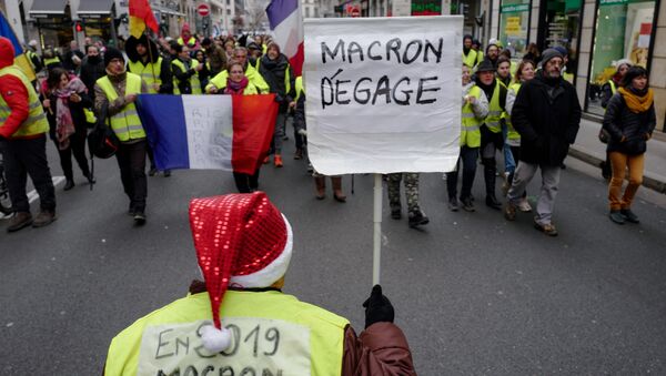 Los 'chalecos amarillos' protestan con el cartel 'Macron, largate!' en París - Sputnik Mundo