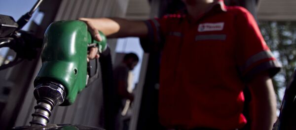 Trabajador de una gasolinera llena el tanque de una motocicleta Trabajador de una gasolinera llena el tanque de una motocicleta - Sputnik Mundo