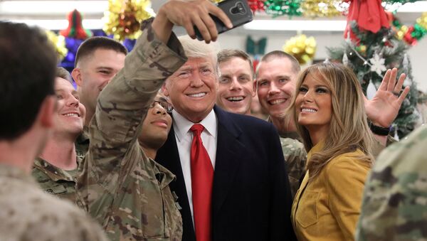 Donald Trump, presidente de EEUU, y su esposa, Melania, posan para una foto al lado de soldados estadounidenses en Irak - Sputnik Mundo