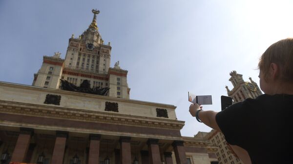 Una estudiante toma una foto de su identificación en la Universidad Lomonósov de Moscú - Sputnik Mundo
