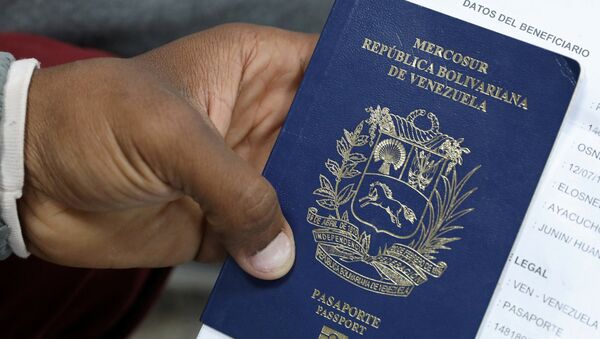 Un migrante venezolano muestra su pasaporte - Sputnik Mundo