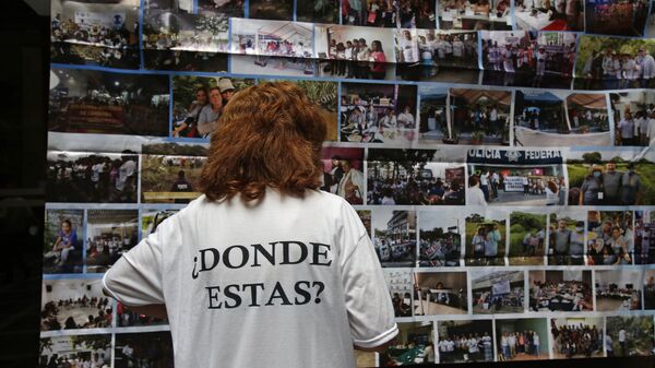 Una persona tiene una camiseta en memoria de los desaparecidos de Ayotzinapa, en México - Sputnik Mundo