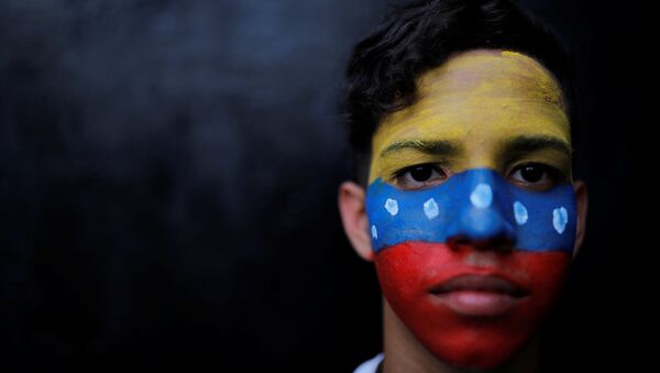Un ciudadano con la bandera de Venezuela en su cara - Sputnik Mundo