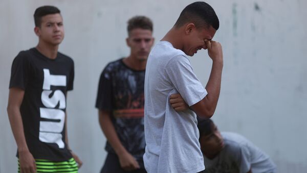 Un jóven llora tras el incendio en un club de fútbol en Río de Janeiro - Sputnik Mundo
