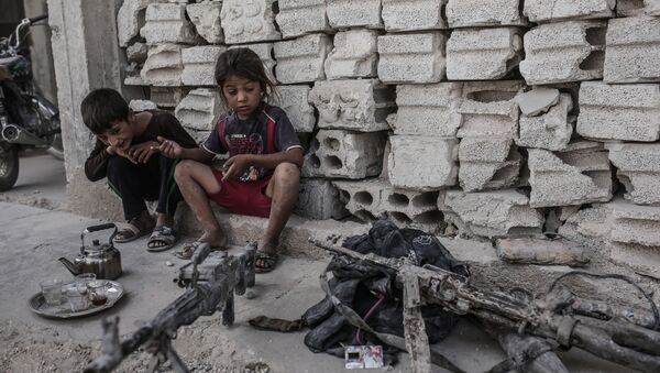 Niños miran en armas incautadas a los terroristas de ISIS en Irak - Sputnik Mundo