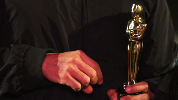 Vecino de la colonia Roma carga una estatuilla de los premios Oscar. - Sputnik Mundo
