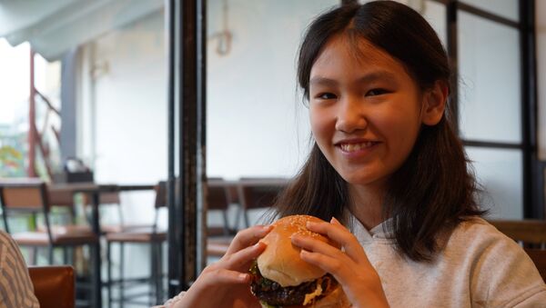 Una joven con una hamburguesa Durty Donald - Sputnik Mundo