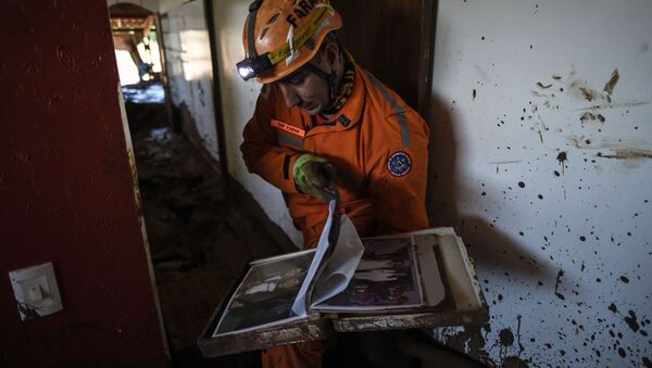 El bombero Leonard Farah rescata las pertenencias de las casas destruidas por el lodo tóxico, un mes después de la ruptura de una presa de la compañía minera Vale en Corrego do Feijao, cerca de Brumadinho, en el estado brasileño de Minas Gerais, el 22 de febrero de 2019 - Sputnik Mundo