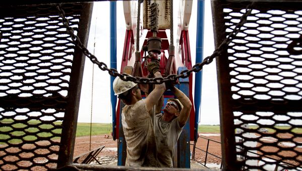 Dos empleados trabajan en una grúa petrolera en EEUU - Sputnik Mundo