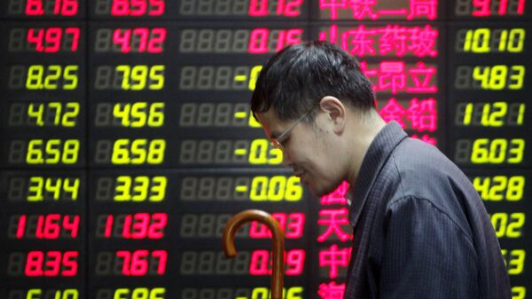 Un hombre cerca de una pantalla con precios en Shanghái - Sputnik Mundo