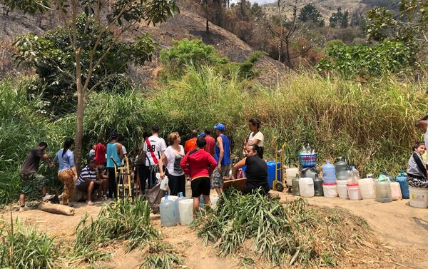 En ocasiones, la gente que espera por llevar agua a sus casas intercambia opiniones sobre la coyuntura venezolana - Sputnik Mundo