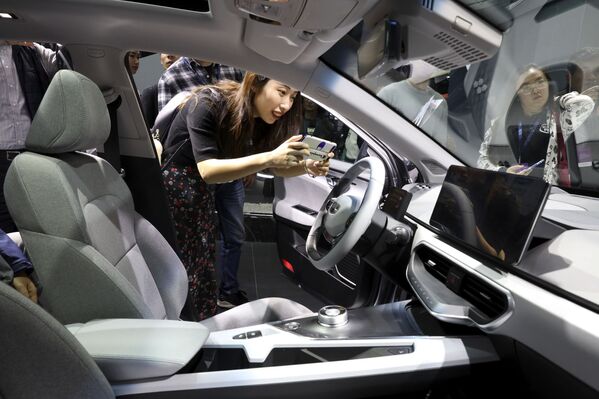 Девушка фотографирует салон автомобиля Geometry компании Geely Auto на Шанхайском международном автосалоне - Sputnik Mundo