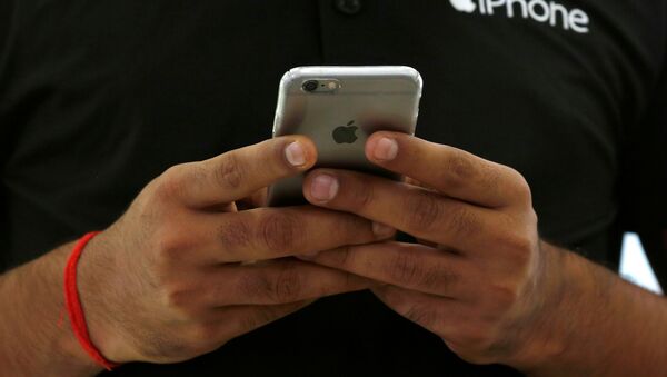 Un dependiente utiliza su iPhone de Apple - Sputnik Mundo