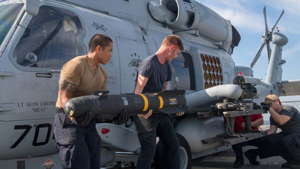Los militares estadounidenses instalan un misil Hellfire en un helicóptero - Sputnik Mundo