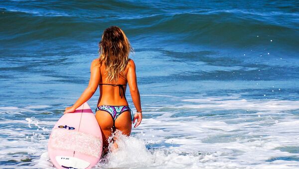 Una mujer en el mar con su tabla de surf - Sputnik Mundo