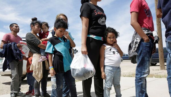 Migrantes centroamericanos hacen cola antes de entrar a un refugio temporal, después de cruzar ilegalmente la frontera entre México y Estados Unidos - Sputnik Mundo