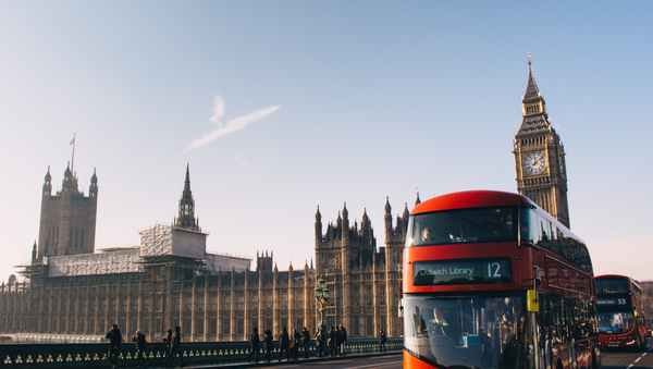Un autobús típico de Londres 'double decker' con el Parlamento británico de fondo (archivo) - Sputnik Mundo