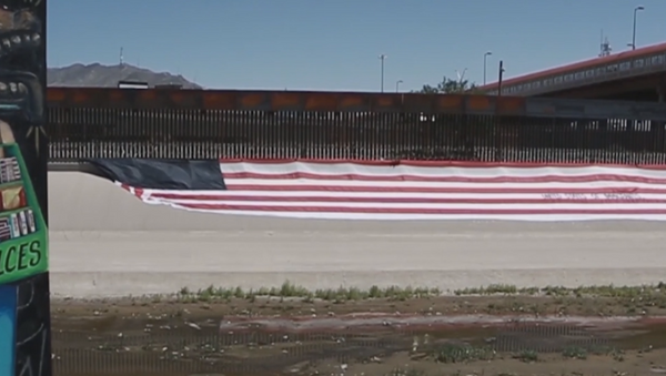 Un estadounidense despliega una bandera de ''Estados Unidos de Migrantes'' - Sputnik Mundo