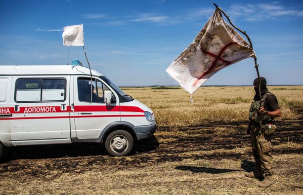Украинский военный с белым флагом во время передачи убитых на нейтральной территории вблизи поселка Диброво в Донецкой области - Sputnik Mundo