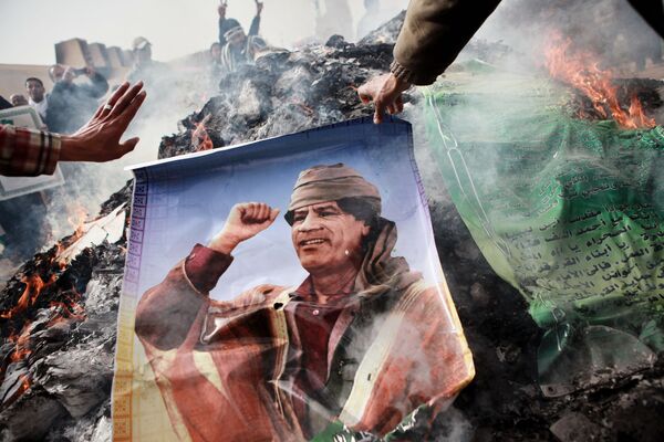 Жители Бенгази сжигают портреты Муамара Каддафи, плакаты с его цитатами и Зеленую книгу Каддафи - Sputnik Mundo
