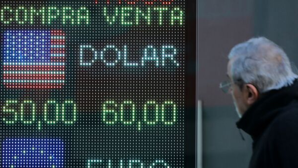 Un hombre mira la devaluación del peso argentino frente al dólar en una pantalla - Sputnik Mundo