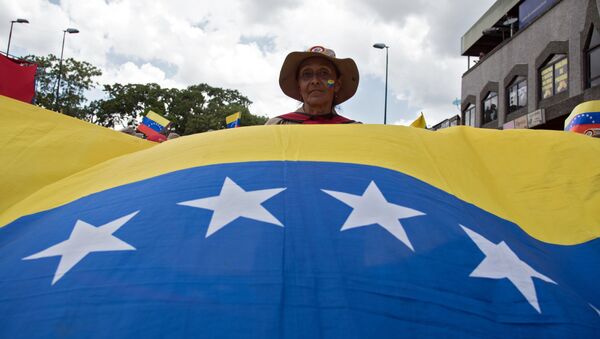 Una participante de una marcha en Caracas contra la política de sanciones de Estados Unidos - Sputnik Mundo