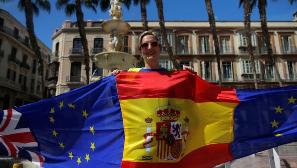 Una manifestante sostiene banderas de España, la UE y el Reino Unido durante una protesta contra el Brexit celebrada en Málaga - Sputnik Mundo