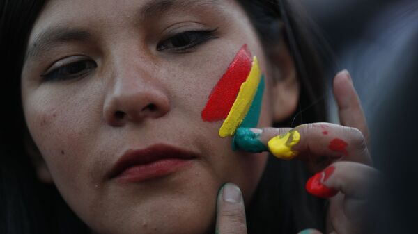 Una mujer pinta los colores de la bandera boliviana en su rostro - Sputnik Mundo