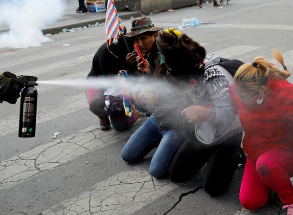 Los manifestantes son rociados con un espray de pimienta por un miembro de las fuerzas de seguridad durante los enfrentamientos entre partidarios del expresidente boliviano, Evo Morales, y las fuerzas de seguridad en La Paz (Bolivia). - Sputnik Mundo