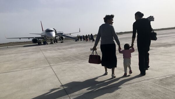 Una familia de uigures en el aeropuerto chino de Kuqa - Sputnik Mundo